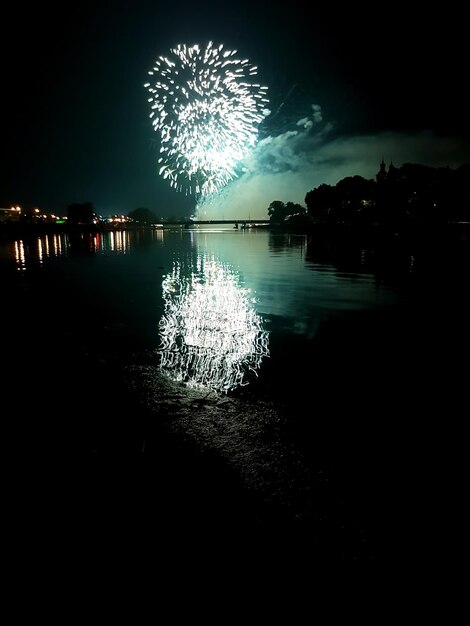 Foto spettacolo di fuochi d'artificio sul lago contro il cielo notturno