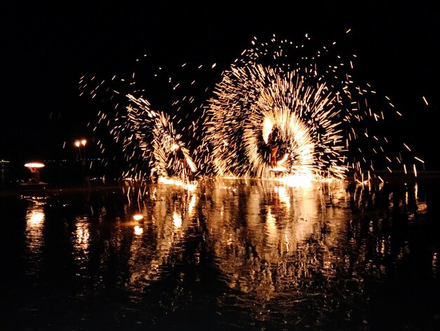 Foto spettacolo di fuochi d'artificio sul lago contro il cielo notturno