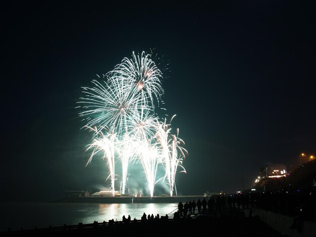 Foto spettacolo di fuochi d'artificio sul mare contro il cielo notturno