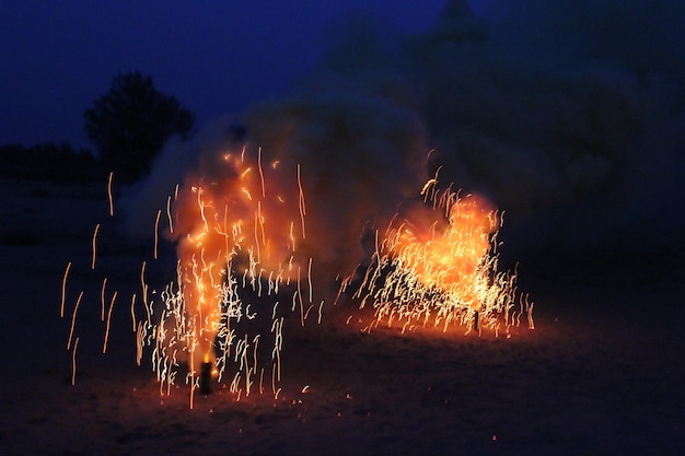 写真 ビーチの砂の上で爆発する花火