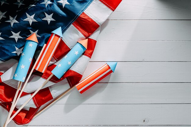 Fireworks and american flag on a white wooden table with place for text 4th july independence day celebration concept