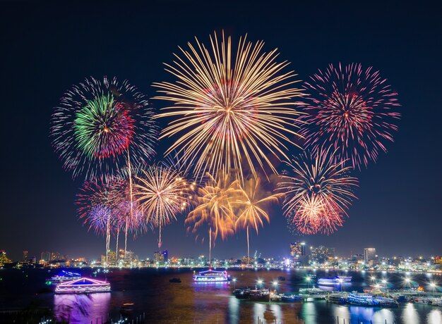 Foto fuochi d'artificio sul paesaggio urbano vicino alla spiaggia e al mare circostante con hotel, ristorante