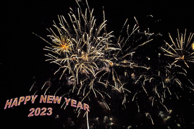 Foto fuochi d'artificio per congratularsi con il nuovo anno 2023 con lettere gialle o dorate