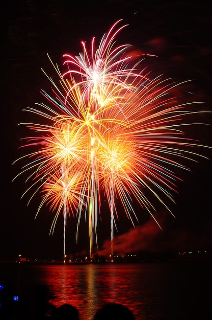 Fireworks light up the sky over river. 