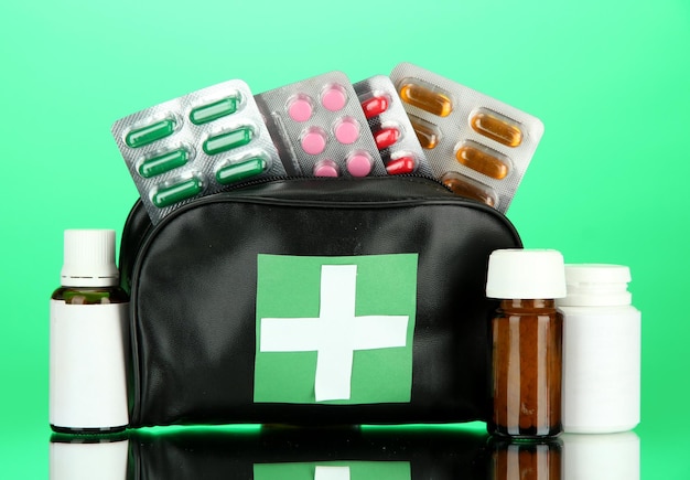 First aid bag on green background