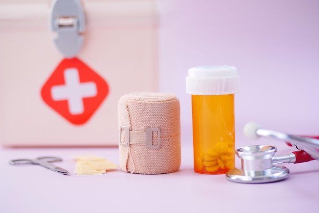 First aid kit box and medical pill on table