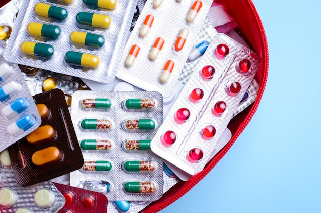 First aid kit with different pills on the blue table