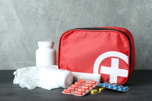 First aid medical kit on dark wooden table