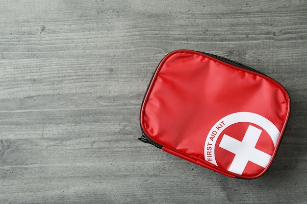 First aid medical kit on gray textured table