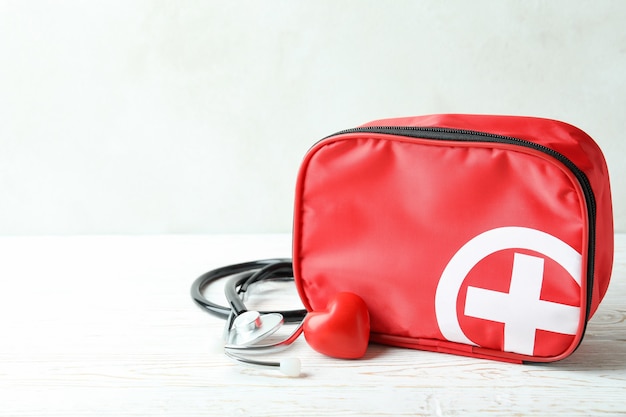 First aid medical kit on white wooden table