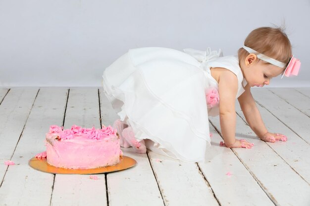 Foto primo compleanno bambina con una torta rosa festiva