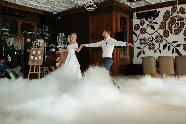 The first dance of the bride and groom inside a restaurant