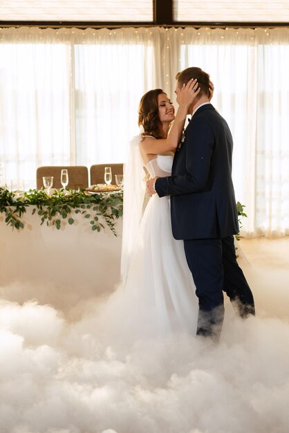 The first dance of the bride and groom inside a restaurant