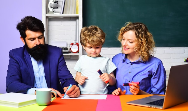 First day at school boy from primary school private lesson male and female teachers helping child