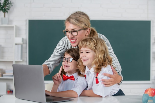 First day at school cute little boy from elementary school and
tutor teacher studying lesson on lapt