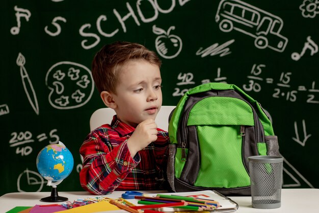 First day of school. Kid boy from primary school. Back to school. Little boy collects school backpack to school. Child from elementary school.