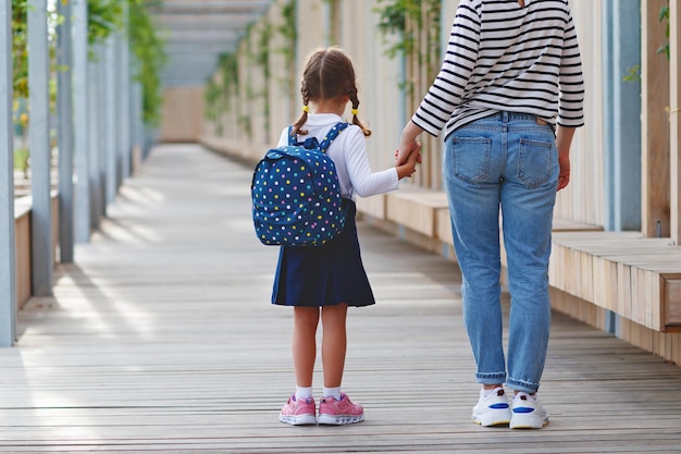 First day at school mother leads a little child school girl in
first grade