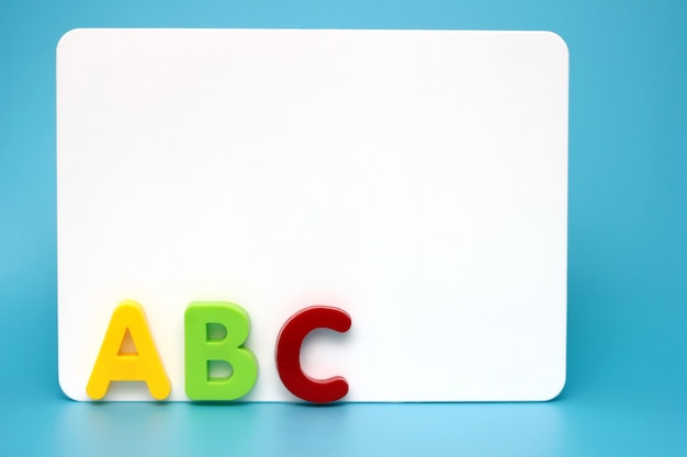 the first letters of the English alphabet near the white Board