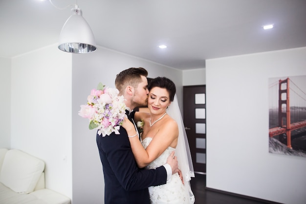 The first meeting. The groom comes into the room to the bride with a bouquet. 