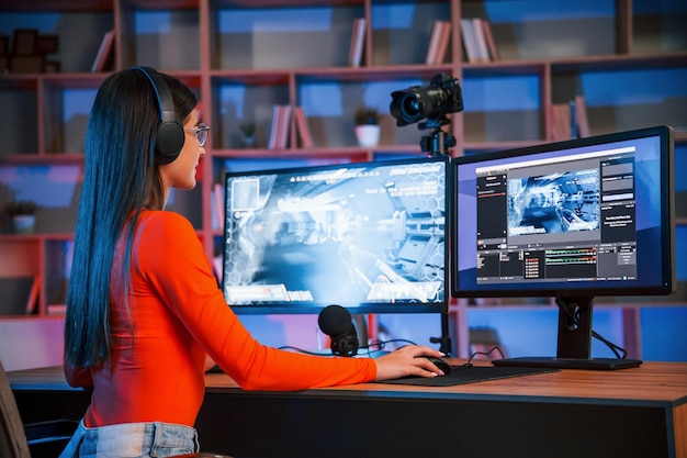 First person shooting game Young beautiful streamer is indoors with pc