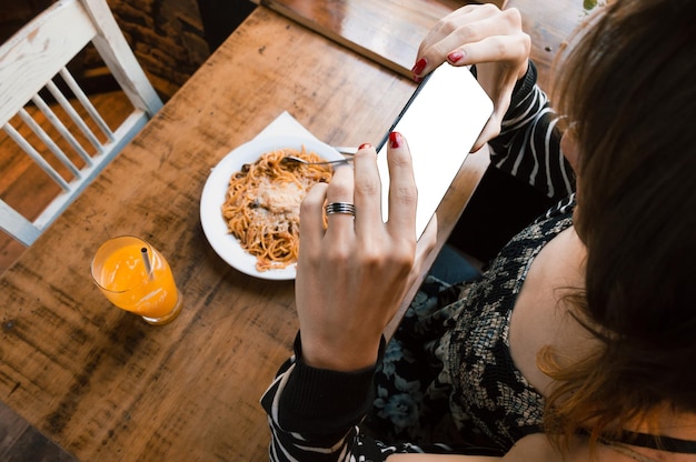 First person top view of transgender woman taking a photo of her food with her phone