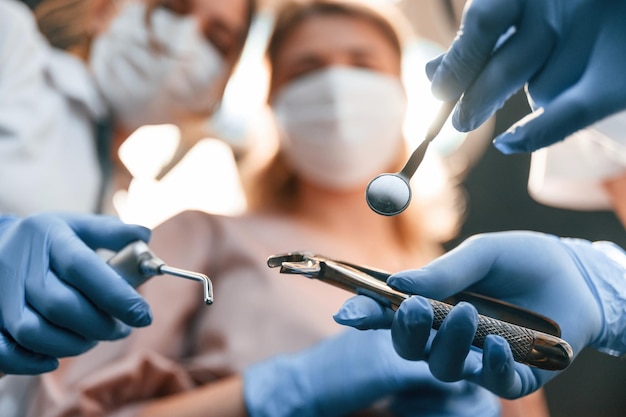 Photo first person view three doctors are working in the stomatological cabinet