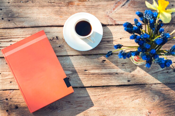 木製の背景の最初の春の花書とコーヒー