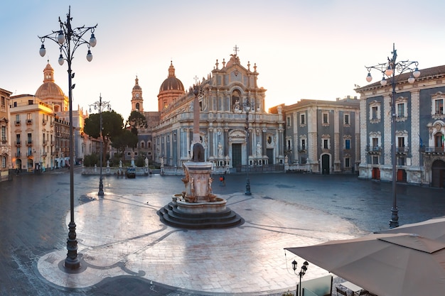 The first sunray on Piazza Duomo in Catania and the Cathedral of Santa Agatha and Liotru, symbol of Catania at sunrise, Sicily,