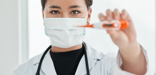 First we need to check your temperature Cropped shot of a medical practitioner holding up a thermometer