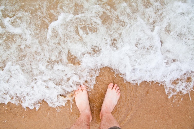 FirstPerson View of Bare Feet on Sandy Michigan Beach with Incoming Waves