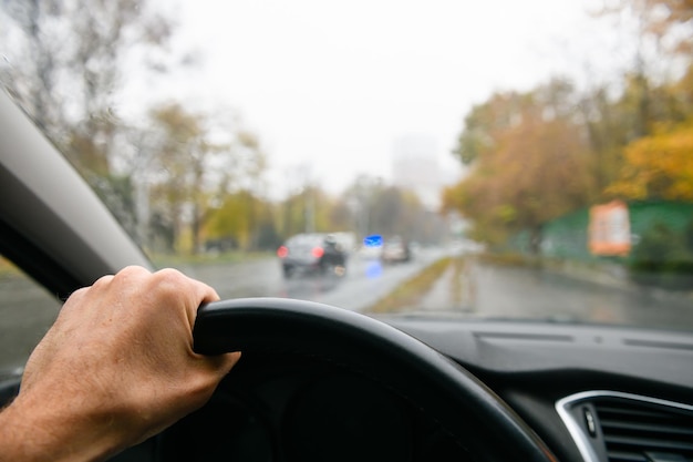 Visuale in prima persona del conducente dell'auto mano d'uomo sul volante auto della polizia sullo sfondo foto di alta qualità