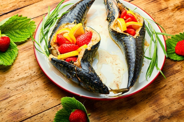 Fish baked with strawberry and lemon in the plate.Summer fish dish,baked mackerel.