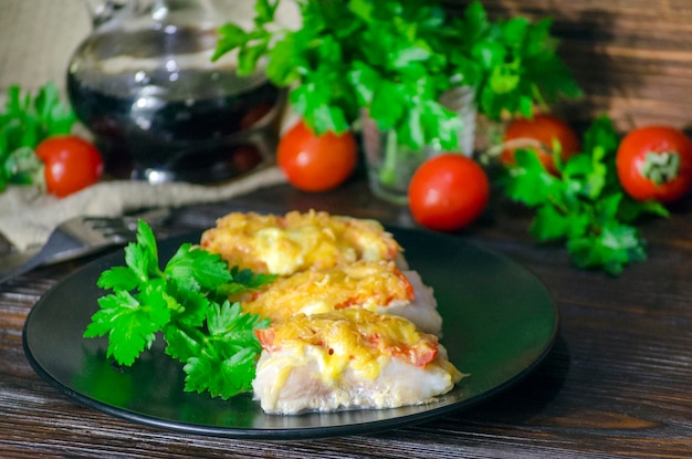 Фото Рыба, запеченная с овощами и сыром в белом соусе на темном фоне