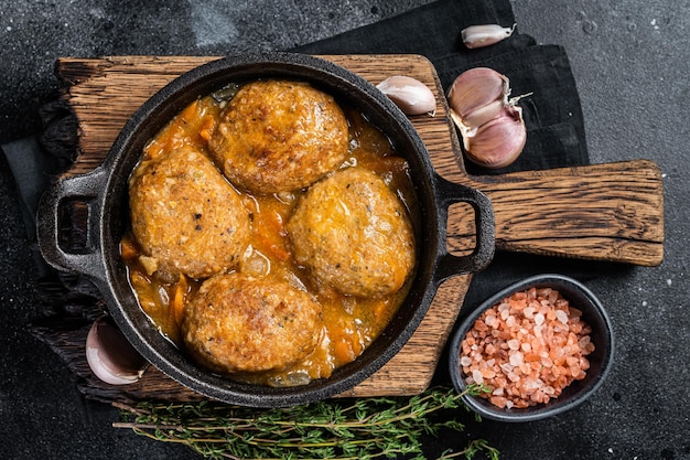 Fish balls with tuna in tomato sauce in a pan Black background Top view