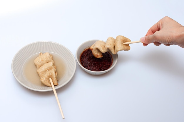 Fish cake skewers in a bowl on a white background