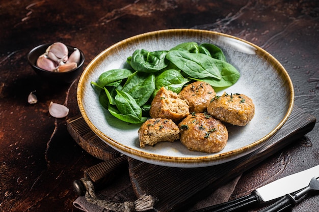 Fish Cakes or Fish balls with tuna and spinach in a plate Dark background Top view