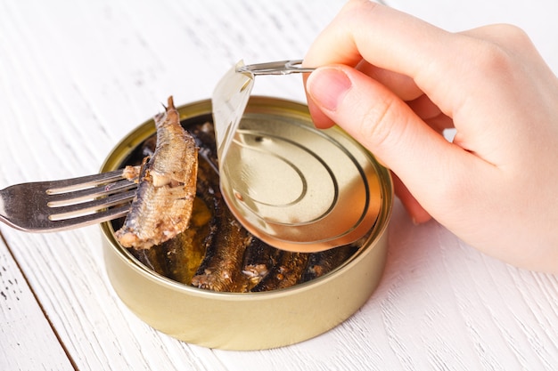 Fish can close up on wooden table with opener