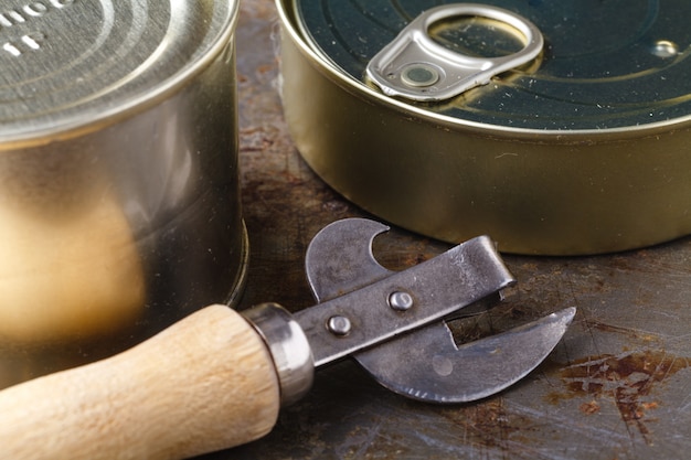 魚は木製のテーブルの缶切りで缶