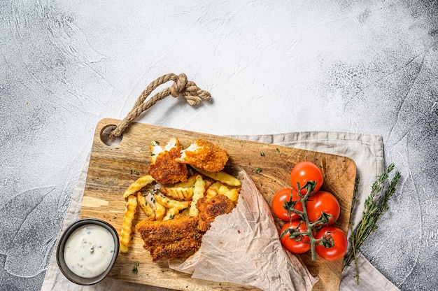 Fish and Chips, british fast food served with Tartar sauce. Gray background