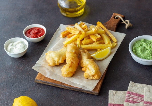 Fish and chips on a dark surface. British fast food. Recipes. Snack to beer. Traditional british food.