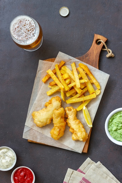 Fish and chips on a dark surface. British fast food. Recipes. Snack to beer. Traditional british food.