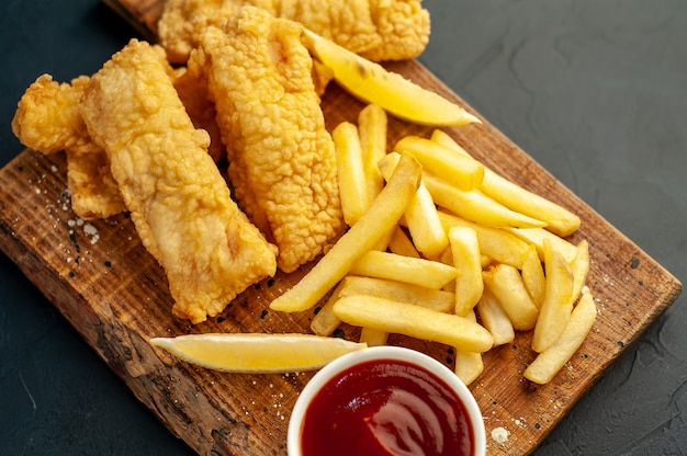 fish and chips with french fries on stone background