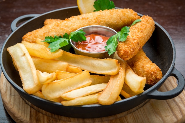 Fish and Chips on wooden table, tasty food.