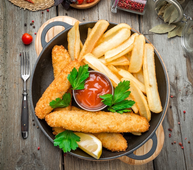 Fish and Chips on wooden table, tasty food.