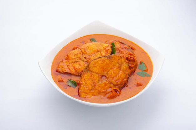 Fish curry_Seer fish curry, традиционное индийское рыбное карри, специальное блюдо из Кералы, расположенное в белой миске, украшенное листьями карри на белом фоне