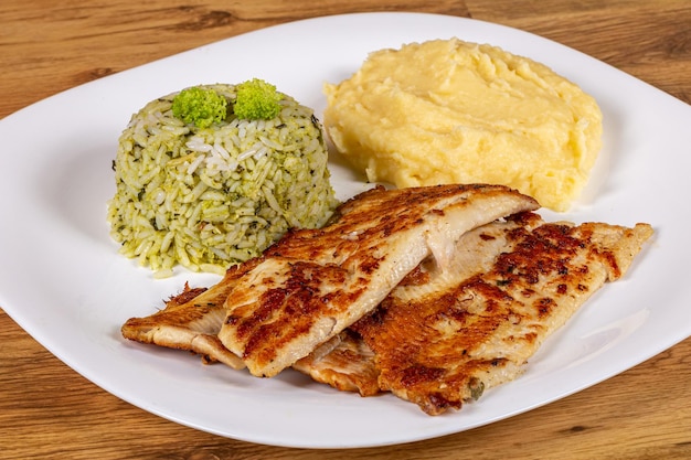 fish fillet served with mashed potatoes and rice with broccoli