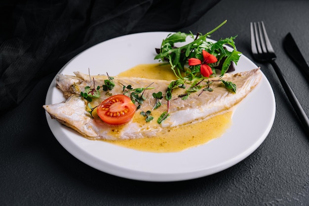 Fish fillet in white sauce on white plate