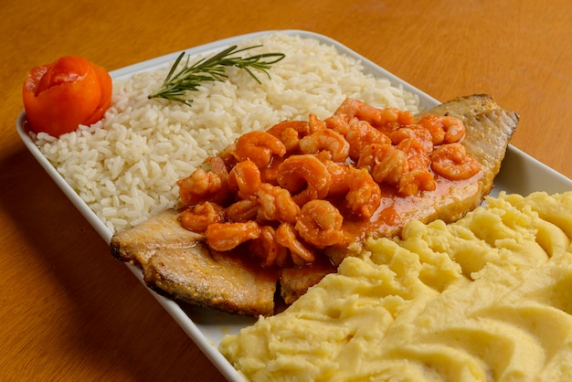 흰 쌀과 으깬 감자와 함께 토마토 소스에 새우를 곁들인 생선 필레