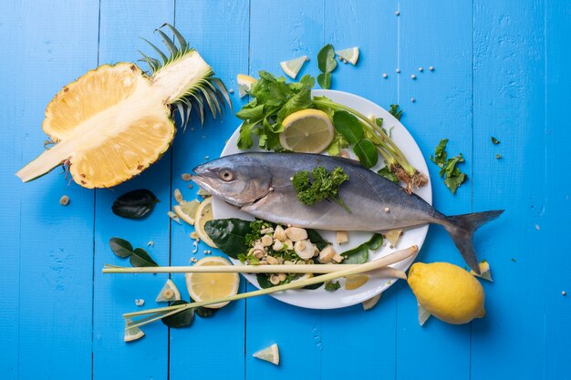 Fish food with ingredient spices on blue table 