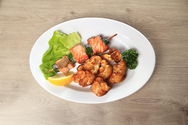 Fish from the barbecue and garnish on the plate in the wooden background